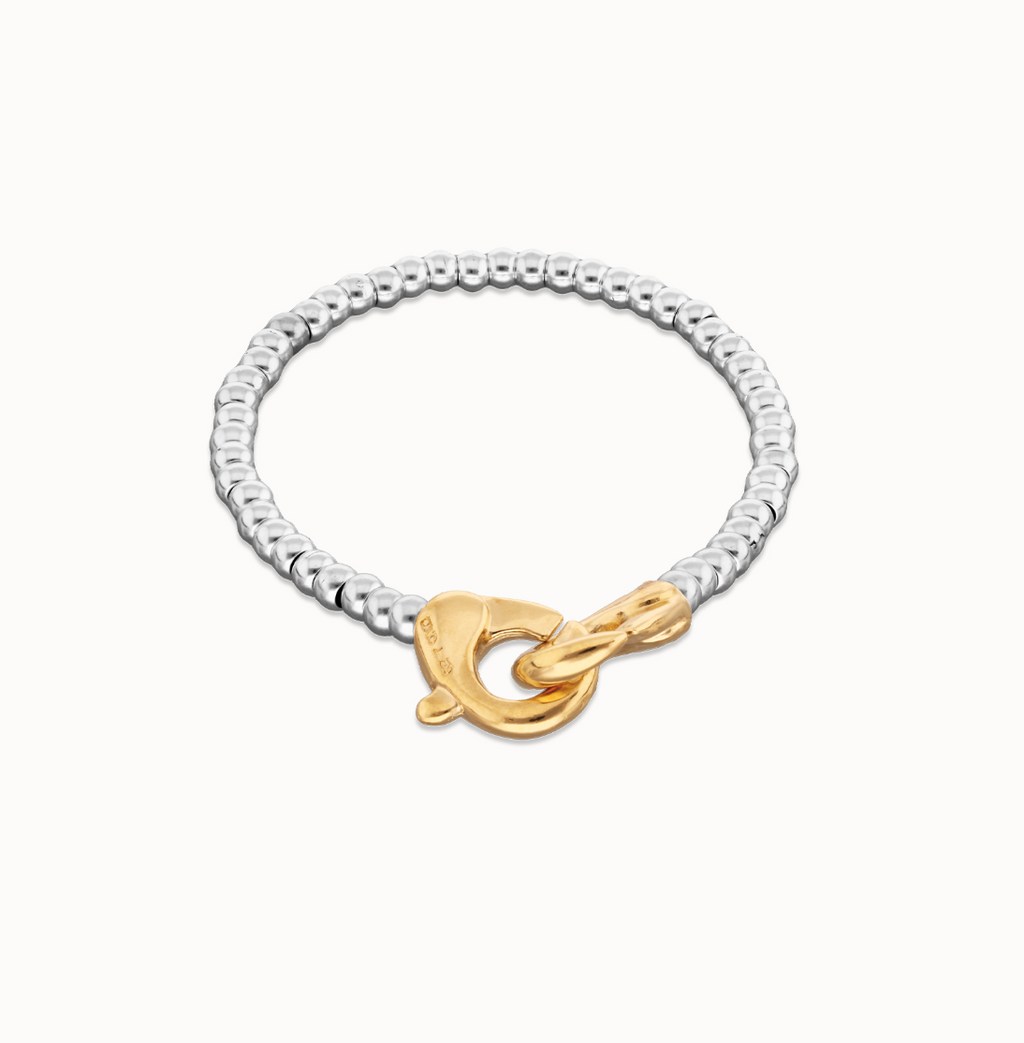 Pulsera de bolas pequeñas bañada en oro con mosqueton entrelazado en oro